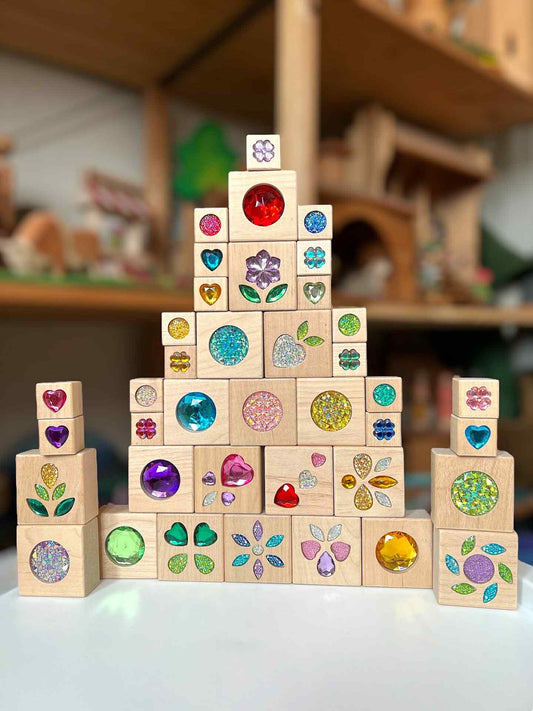 Stack of wooden blocks with colorful embellishments on a blurred indoor background
